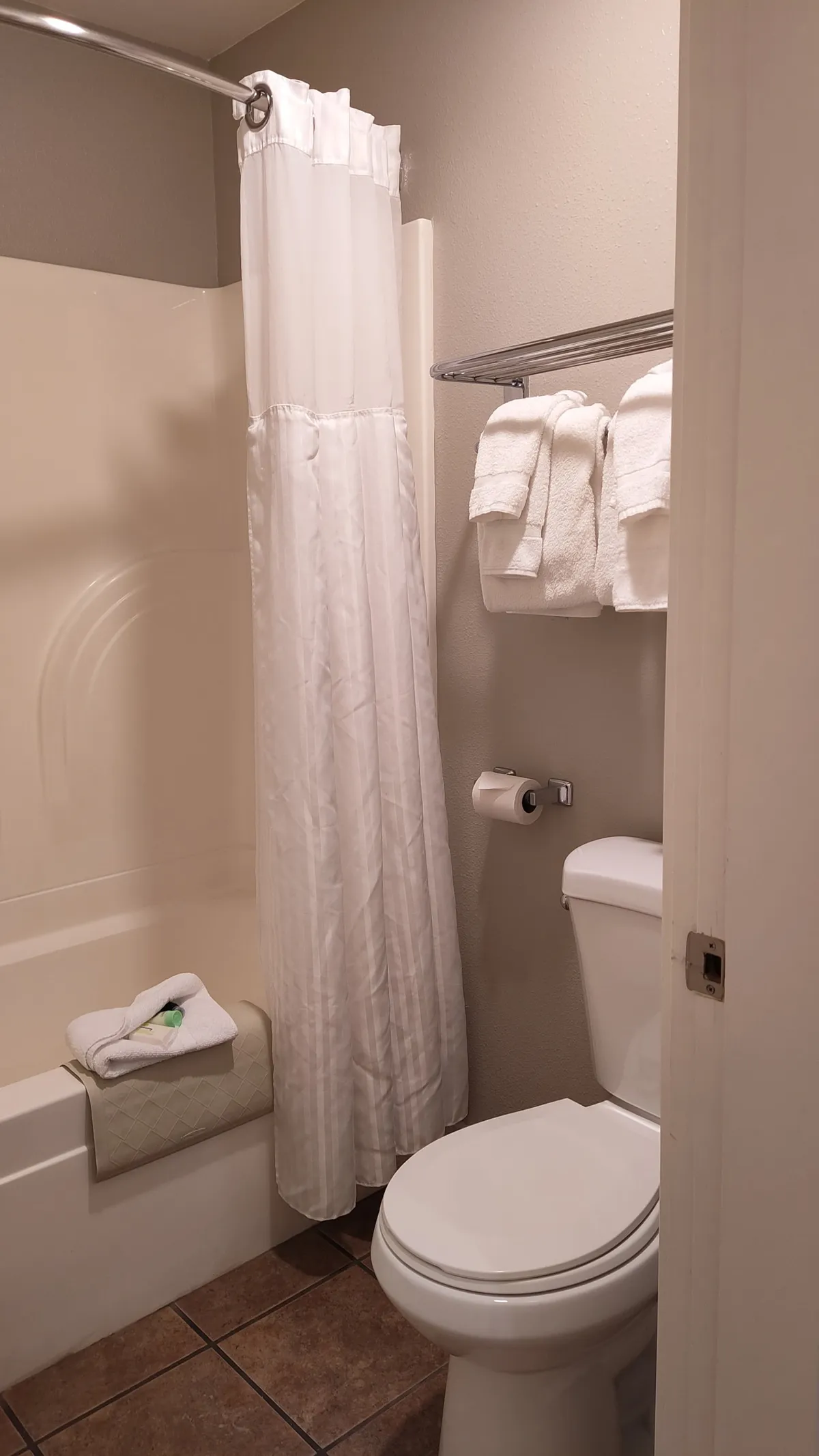 A bright and clean bathroom with a full tub and shower combo, complemented by fresh towels, a modern vanity, and a calming palette. The bathroom exudes a spa-like feel, ideal for a soothing soak or refreshing rinse after a long day outdoors.