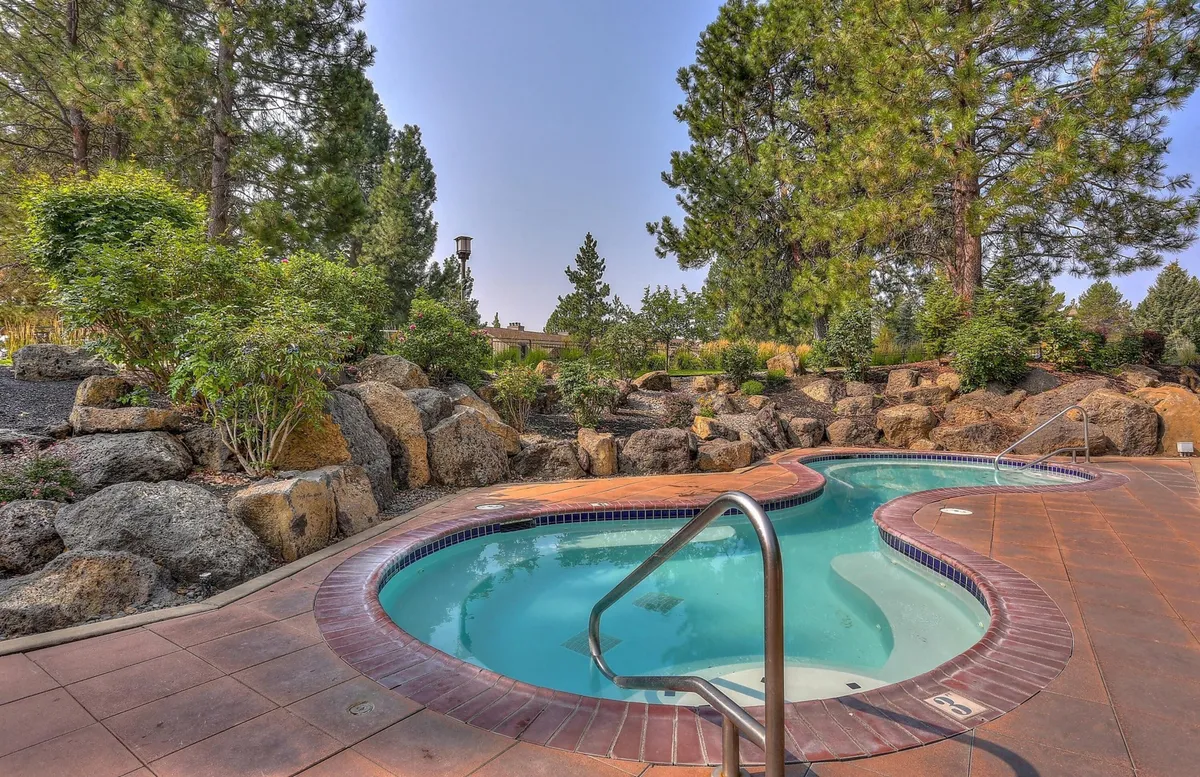 An inviting hot tub set amidst natural rocks and lush greenery, blending relaxation with the surrounding outdoor environment. The image highlights moments of unwinding after a day of adventure, surrounded by nature.